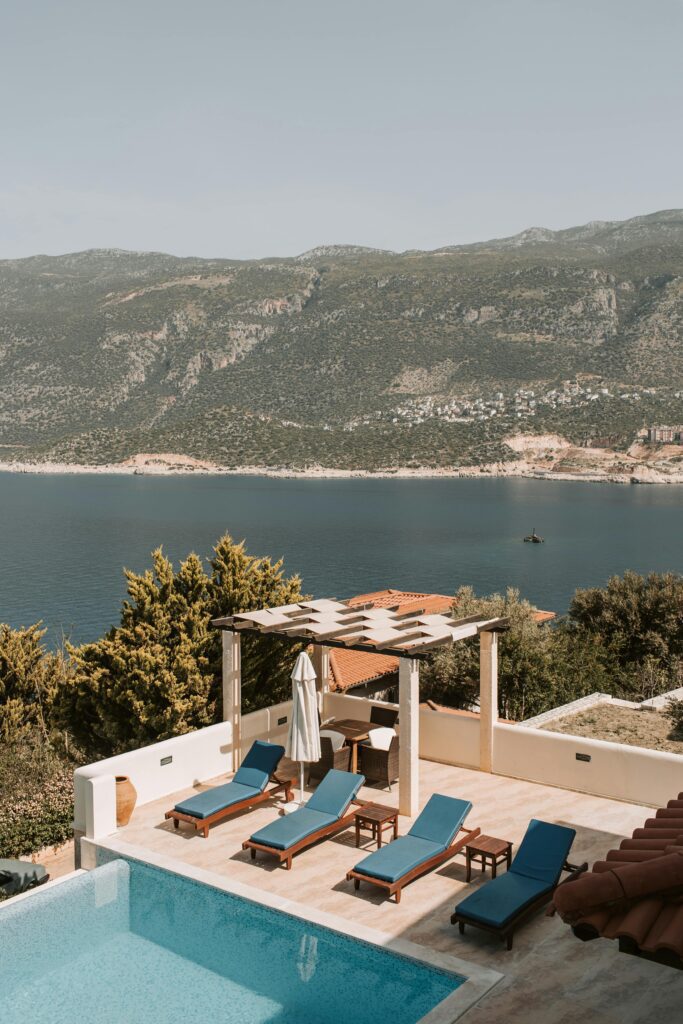pexels-photo-7903136-7903136 Stunning poolside view from a luxurious villa in Antalya, Turkey, over blue waters.